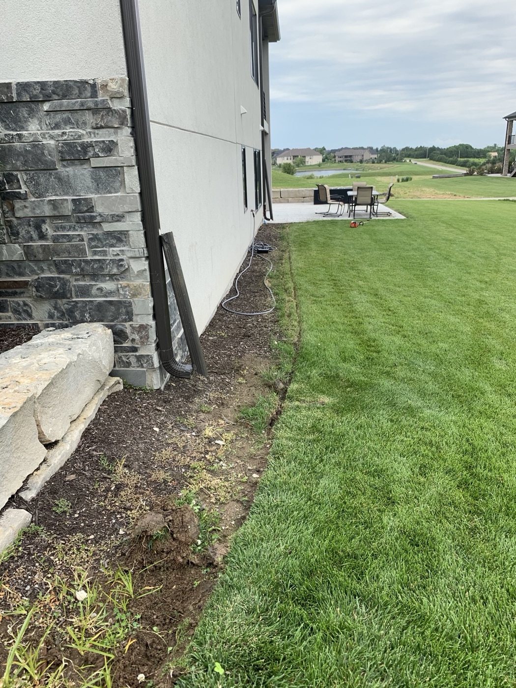 Foundation bed cleared of grass and prepped for mulch at a Lincoln NE home — real Ohana Lawn Care job