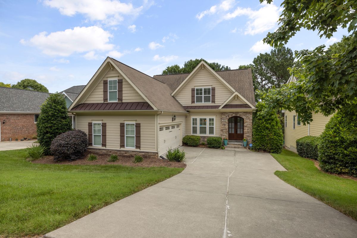 Beautifully landscaped residential home with manicured lawn, mulched beds, and trimmed shrubs